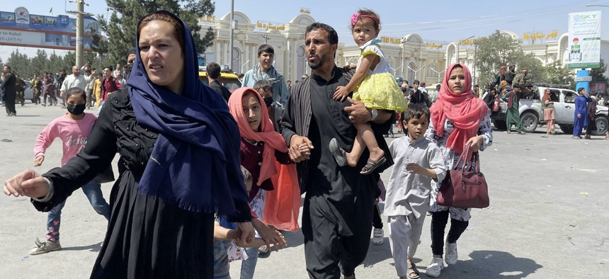An Afghan family rushes to the Hamid Karzai International Airport as they flee the Afghan capital of Kabul, Afghanistan, on August 16, 2021. 
