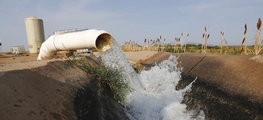 Water flows into a canal that feeds farms in Casa Grande, Ariz