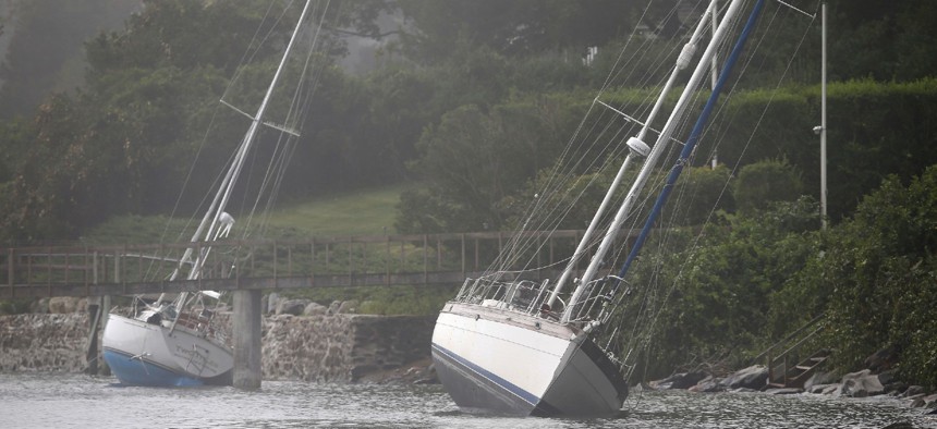 Two sailboats that came loose from their moorings and ran aground during Tropical Storm Henri still sit on the rocks in Jamestown, R.I., Monday.