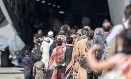 Families board a U.S. Air Force Boeing C-17 Globemaster III during an evacuation at Hamid Karzai International Airport in Kabul on Aug. 24.