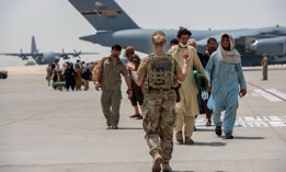 A member from the 379th Air Expeditionary Wing guides qualified evacuees debarking a C-17 Globemaster lll on Aug. 23 at Al Udeid Air Base, Qatar. 