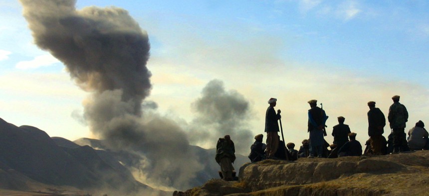 Northern Alliance soldiers watch as U.S. air strikes attack Taliban positions in Kunduz province, Afghanistan, Nov. 19, 2001.
