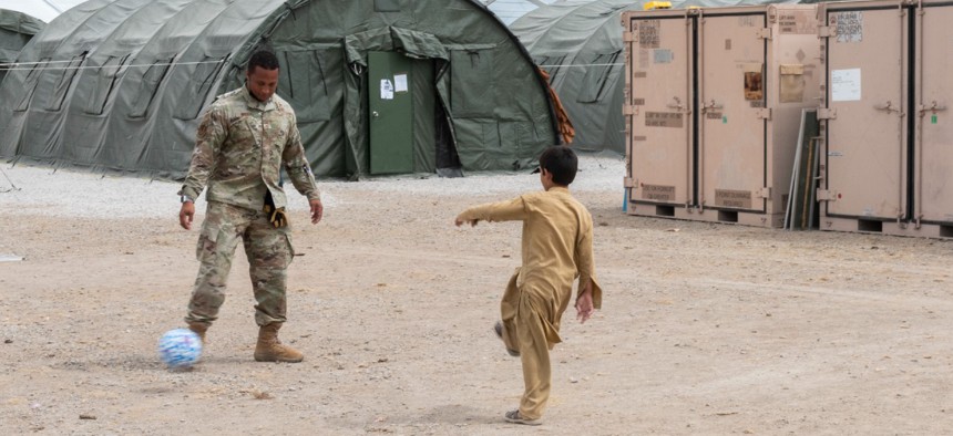 An Airman from Task Force-Holloman plays soccer with an Afghan evacuee at the Afghan personnel camp on Holloman Air Force Base, New Mexico on September 1. 