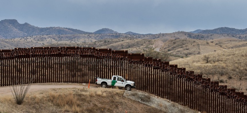 A Border Patrol officer sits inside his car as he guards the U.S.-Mexico border fence in Nogales, Arizona, in 2019. 