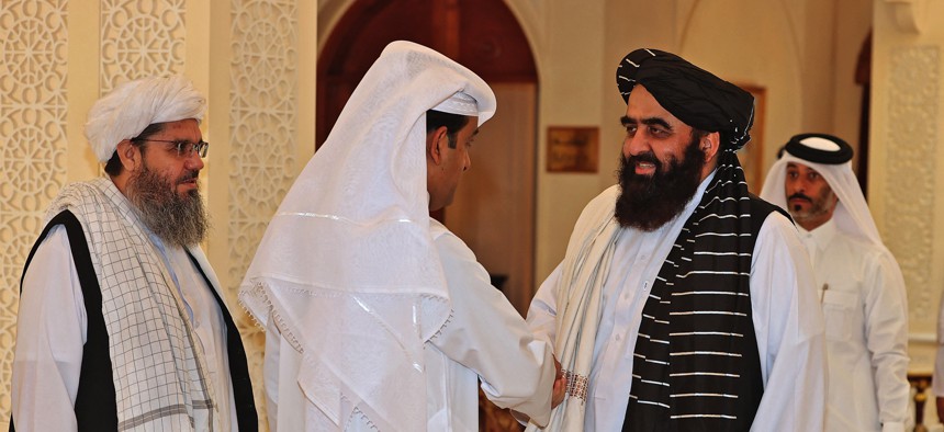 Qatar's envoy on counter-terrorism Mutlaq al-Qahtani, left, shakes hands with Taliban co-founder Mullah Abdul Ghani Baradar in Qatar's capital Doha, on October 12, 2021.