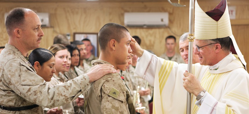 Archbishop Timothy P. Broglio, right, who leads the Roman Catholic Archdiocese for the military services, confirms service members into the Catholic faith at Camp Leatherneck, Afghanistan, in 2014.