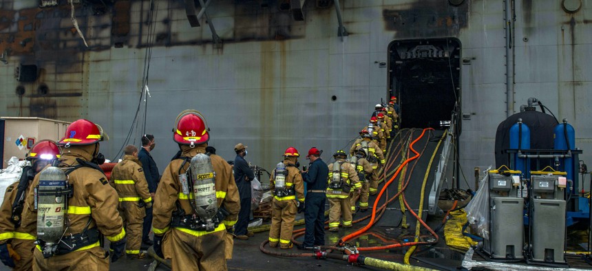 Sailors prepare to board the amphibious assault ship USS Bonhomme Richard (LHD 6) at Naval Base San Diego, July 14, 2020, to support firefighting efforts.