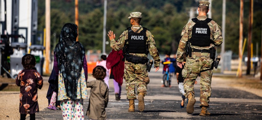 U.S. Military Police walk past Afghan residents at Fort McCoy U.S. Army base in Wisconsin in September.