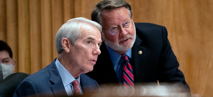 Sen. Rob Portman, R-Ohio, left, speaks to Sen. Gary Peters, D-Mich., during a Senate Homeland Security and Governmental Affairs Committee hearing in September. The two are among a group of lawmakers seeking information about how the FBI treats whistleblowers.