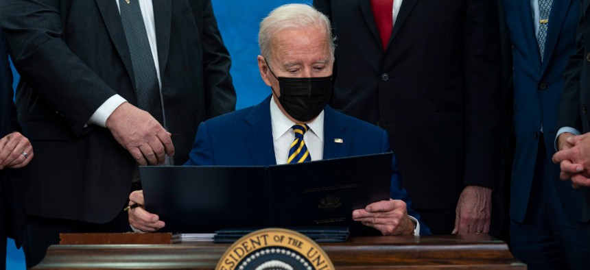 President Biden reads S. 894, “Hire Veteran Health Heroes Act of 2021,” during a bill signing ceremony in the South Court Auditorium on the White House campus on Tuesday. 