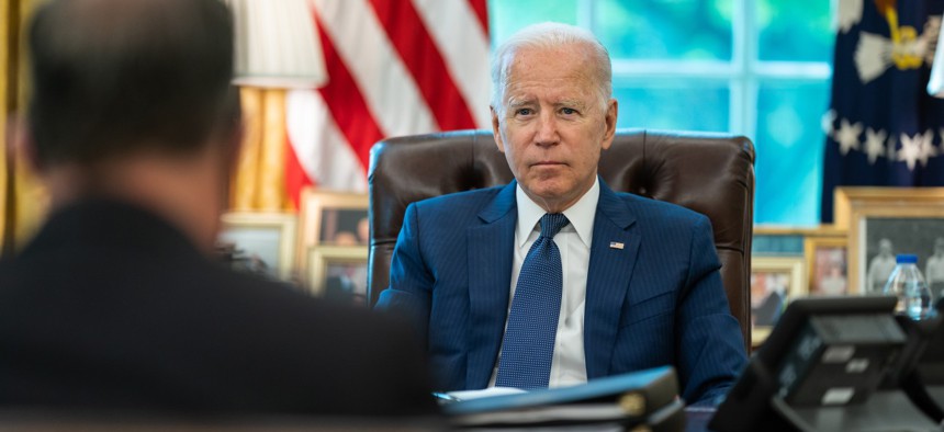 President Biden meets with White House staff in the Oval Office of the White House in August.