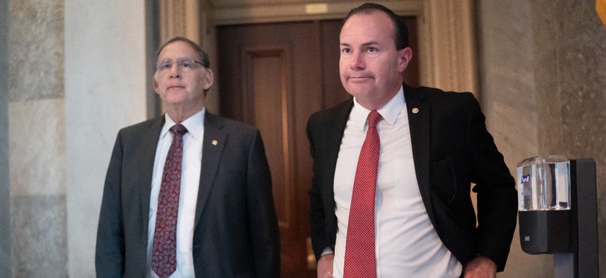 Sen. Mike Lee, R-Utah, and Sen. John Boozman, R-Ark., left, leave a private GOP lunch meeting as Lee continues to press for a vote on his proposal barring vaccine mandates that the Biden administration has ordered.