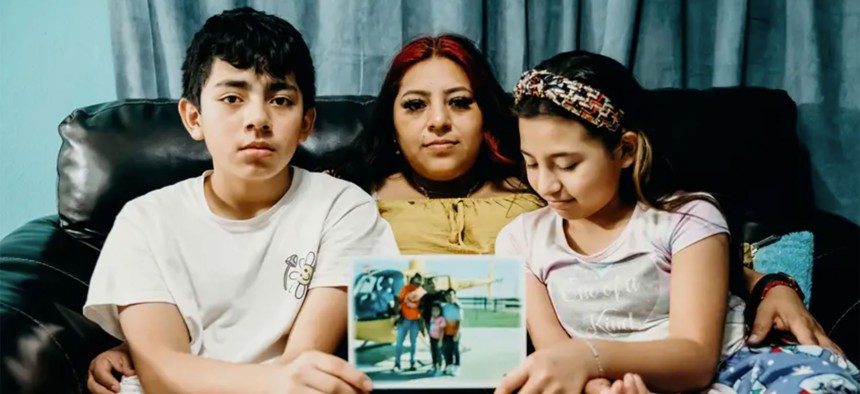 Guadalupe Martinez, 33, and her children Kevin, 13, and Ashley, 9, hold a photo of her husband Juan Reyna, who has been held in an immigration detention center for 11 months.