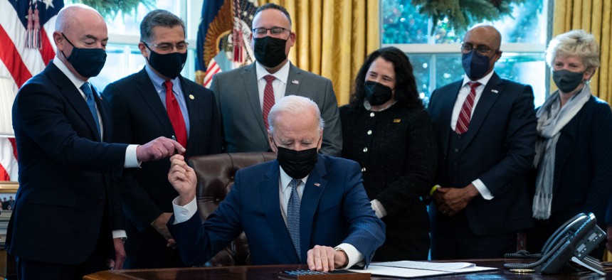 President Biden hands a pen to Homeland Security Secretary Alejandro Mayorkas during the signing Monday of an executive order to improve government services. 