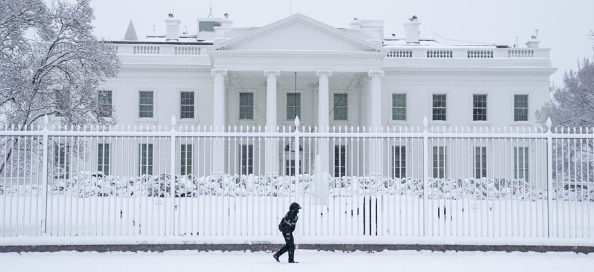 A member of the U.S. Secret Service walks past the White House during a snowstorm on Monday. 