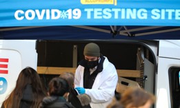 A medical worker wearing a face mask collects a sample at a COVID-19 testing site in Manhattan of New York on Jan. 19.