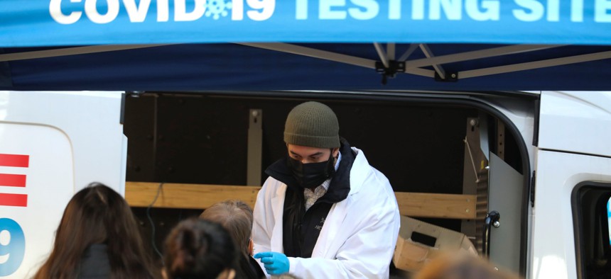 A medical worker wearing a face mask collects a sample at a COVID-19 testing site in Manhattan of New York on Jan. 19.