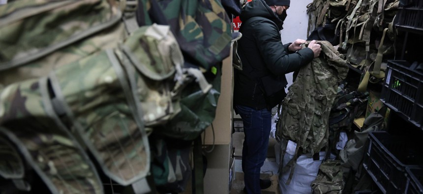 A customer inspects a camouflage backpack in the military surplus shop of Andriy Stovbyha on January 24 in Kyiv, Ukraine. Stovbyha, who sells military surplus boots, clothing, sleeping bags, backpacks and other accessories, says he has seen a sharp increase in the number of customers at his shop since Russian troops began massing at Ukraine's borders in December. 