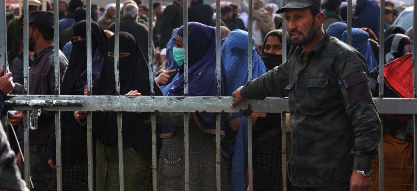 Afghans wait in lines for hours to receive food aid provided by international humanitarian organizations in Kabul, Afghanistan on December 7, 2021. 