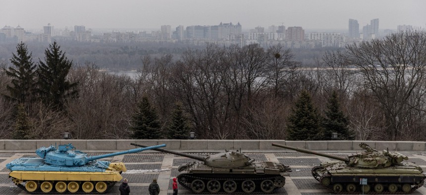 A family walks past a tank displayed at the Motherland Monument on newly created "Unity Day" on February 16, in Kyiv, Ukraine. 