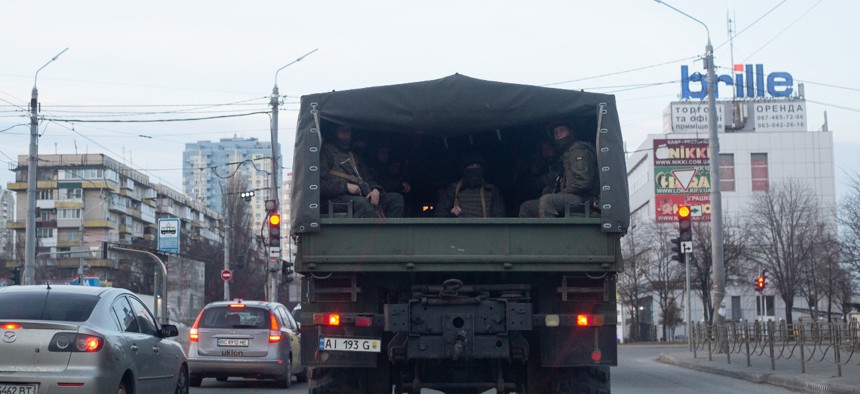 A military vehicle with Ukrainian servicemen drives down the road on February 25 in Kyiv, Ukraine. 