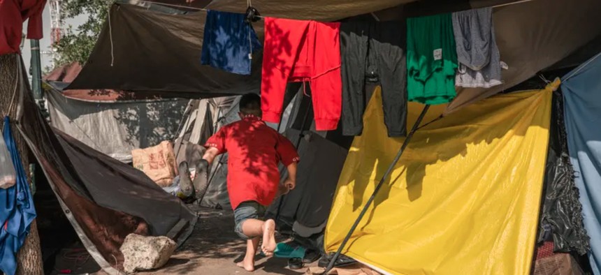 A child runs through the tent city set up in Plaza de la República in Reynosa, across the international border from McAllen, on May 29, 2021. Title 42, a pandemic-era health policy, prevented migrants from seeking asylum in the United States and forced them back to their country of origin or into makeshift encampments in Mexico. Texas sued the Biden administration on Friday to stop it from lifting the order.