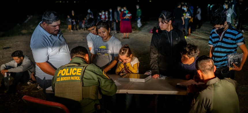 Border Patrol officers process a migrant family after they crossed the Rio Grande into the U.S. on May 05, 2022 in Roma, Texas.