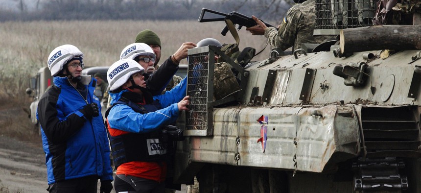 Observers of the Organization for Security and Co-operation in Europe (OSCE) monitor the withdrawal of the Ukrainian forces near Bogdanivka village in the Donetsk region on November 9, 2019.