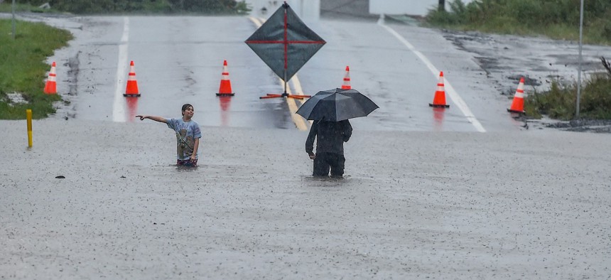 A man and young girl made their way through a flooded main street in Pittston, Pa., in September 2021, as flash flooding due to Hurricane Ida had closed many streets throughout the area. “Children can lose their parents, face food insecurity, and become homeless after floods, hurricanes and other extreme weather catastrophes,” according to Rep. Donald M. Payne Jr., who introduced the bill.