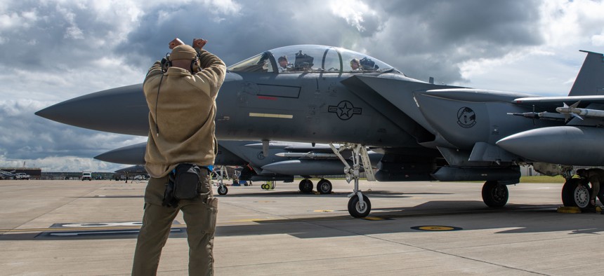 U.S. Air Force Staff Sgt. Tahraun Sibley, an avionics craftsman assigned to the 492nd Aircraft Maintenance Unit, signals an F-15E Strike Eagle after a routine flight operation at Royal Air Force Lakenheath, England, June 8, 2022. 