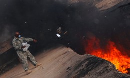 Master Sgt. Darryl Sterling throws unserviceable uniform into a burn pit in Iraq in 2008.