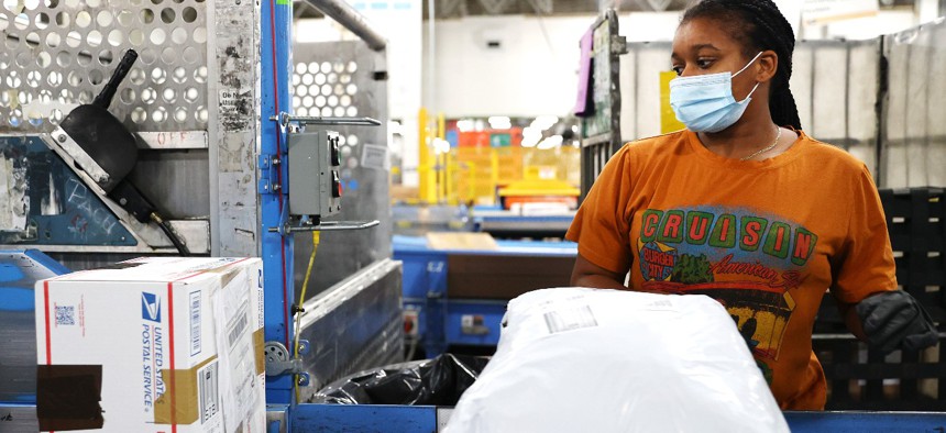  A U.S. Postal Service employee sorts parcels for distribution inside the Los Angeles Mail Processing & Distribution Center, the largest in the United States, on November 22, 2021.