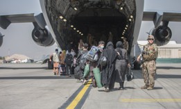 Families begin to board a U.S. Air Force Boeing C-17 Globemaster III during an evacuation at Hamid Karzai International Airport on Aug. 23, 2021.