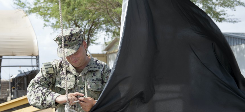 Hospital Corpsman 3rd Class William S. Begley, assigned to the Expeditionary Medical Facility at Camp Lemonnier, Djibouti, hoists a black Wet Bulb, Globe Temperature Index flag to indicate extreme hot weather conditions on base, Oct. 3, 2020. 