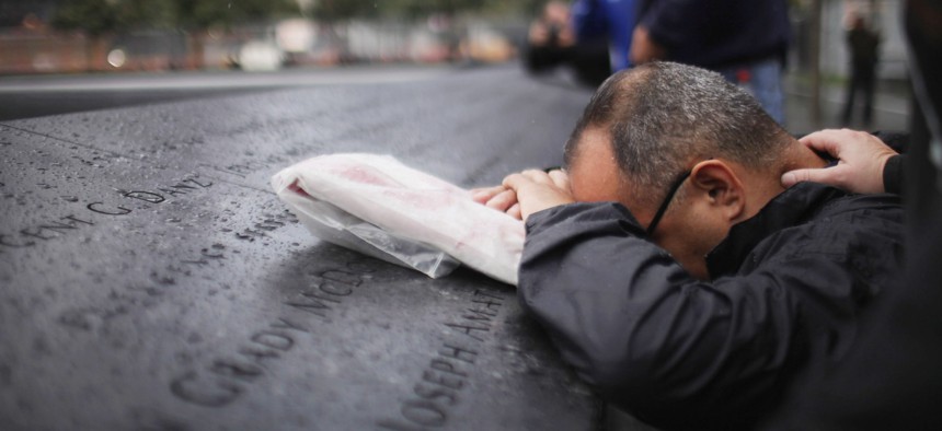 Eddie Reyes is comforted while remembering fifteen of his colleagues in the New York Police Department Emergency Service Unit who were killed on September 11, 2001 during a first responders wreath-laying ceremony at the National September 11 Memorial on September 20, 2011 in New York.