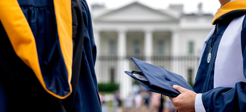 Students from George Washington University wear their graduation gowns outside of the White House in Washington, DC, on May 18, 2022.
