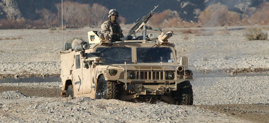 Members of the 3rd Special Forces Group drive a High Mobility Multi-Wheeled Vehicle through a river on the way to the Daychopan region of Afghanistan in 2003.