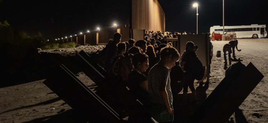Immigrants are processed by the U.S. Border Patrol after crossing the border from Mexico on Aug. 20, 2022 in Yuma, Ariz. Officials say Border Patrol encounters spiked from 400,000 in fiscal 2020 to 1.6 million in fiscal 2021.