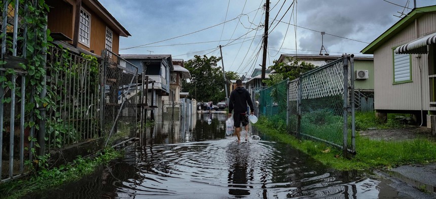 A man walks down a flooded street in the Juana Matos neighborhood of Catano, Puerto Rico, on Sept. 19, 2022, after the passage of Hurricane Fiona. - Hurricane Fiona smashed into Puerto Rico, knocking out the US island territory's power while dumping torrential rain and wreaking catastrophic damage before making landfall in the Dominican Republic on Sept. 19. 