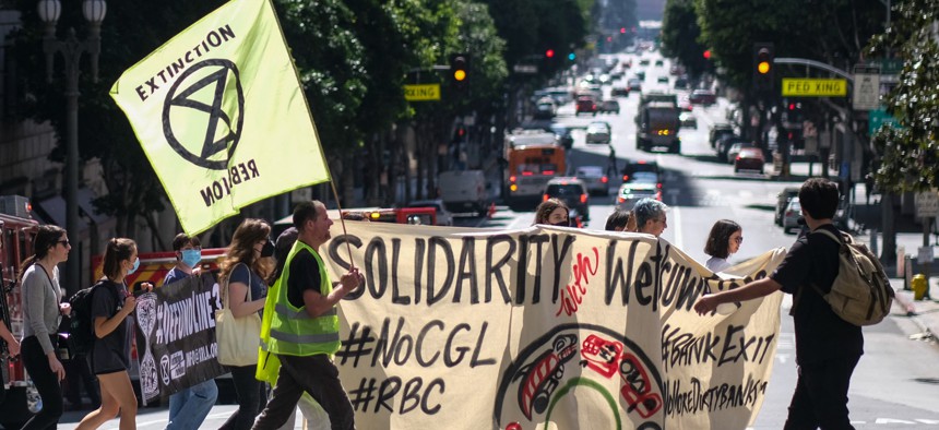 Demonstrators march during a rally to protest City National Bank and Royal Bank of Canada's financing of climate crises and disregard for the rights of indigenous peoples, in Los Angeles in March.