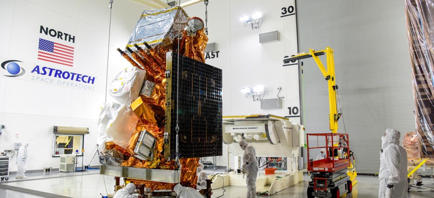 Technicians help secure NASA and the National Oceanic and Atmospheric Administration’s (NOAA) Joint Polar Satellite System-2 (JPSS-2) satellite onto an integration and testing cart inside the Astrotech Space Operations facility at Vandenberg Space Force Base in California on Aug. 22.