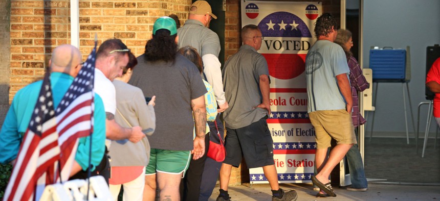 Voters wait in line to cast their ballots in the midterm elections at a polling station in Kissimmee, Florida on Tuesday.