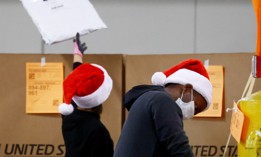 U.S. Postal Service employees sort parcels for distribution inside the Los Angeles Mail Processing & Distribution Center, the largest in the United States, on November 22, 2021.