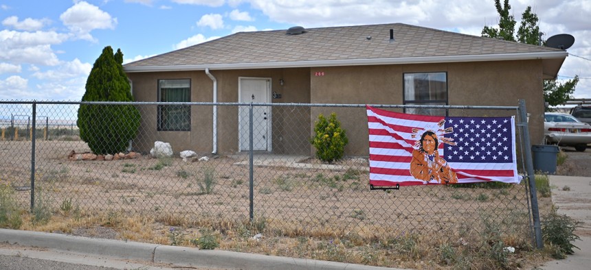 An American flag with an image of Native American on it is attached to a fence outside a home in the East To’Hajiilee housing community amid the spread of the coronavirus on May 25, 2020, in To’Hajiilee Indian Reservation, New Mexico.
