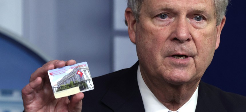 U.S. Secretary of Agriculture Tom Vilsack holds up an Electronic Benefits Transfer at a White House press briefing in May, 2021.