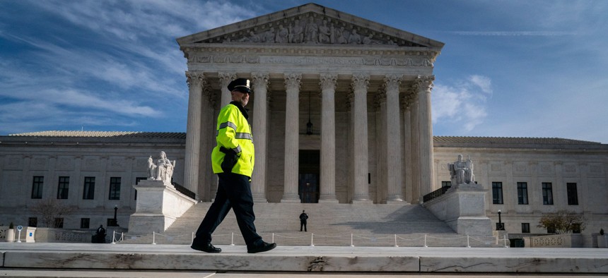 A Supreme Court Police Officer stands on the steps of the Supreme Court on Dec. 5.