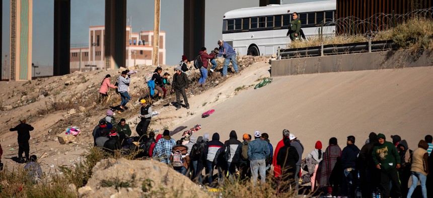 Hundreds of migrants wait in line along the banks of the Rio Grande to seek asylum in the U.S. on Dec. 12. On Saturday, days before Title 42 was expected to be lifted, El Paso’s mayor declared a state of emergency, citing an increase in migrants and cold weather.