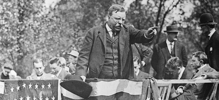 Theodore Roosevelt standing on a podium pointing into the crowd during a campaign rally speech. Ca. 1900s.