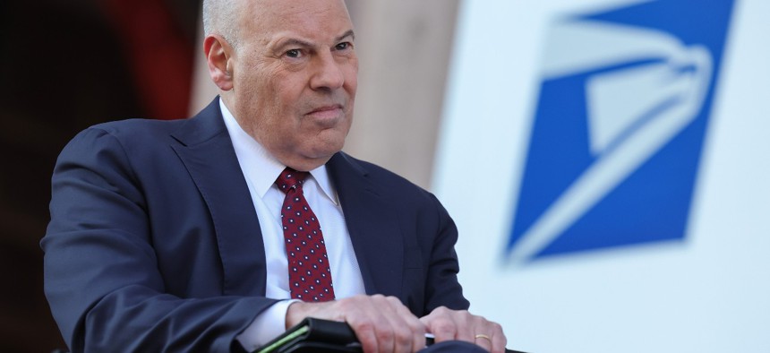 Postmaster General Louis Dejoy attends an event announcing the Postal Service's plan on implementing electric vehicles, at the Postal Service Headquarters on December 20, 2022.