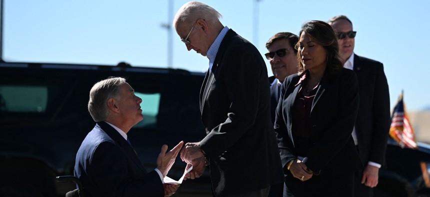 President Joe Biden shakes hands with Texas Gov. Greg Abbott upon Biden’s arrival in El Paso on Sunday. This is his first visit as president to the U.S.-Mexico border.